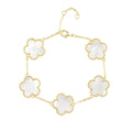 Gold bracelet with white flower-shaped links on a white background